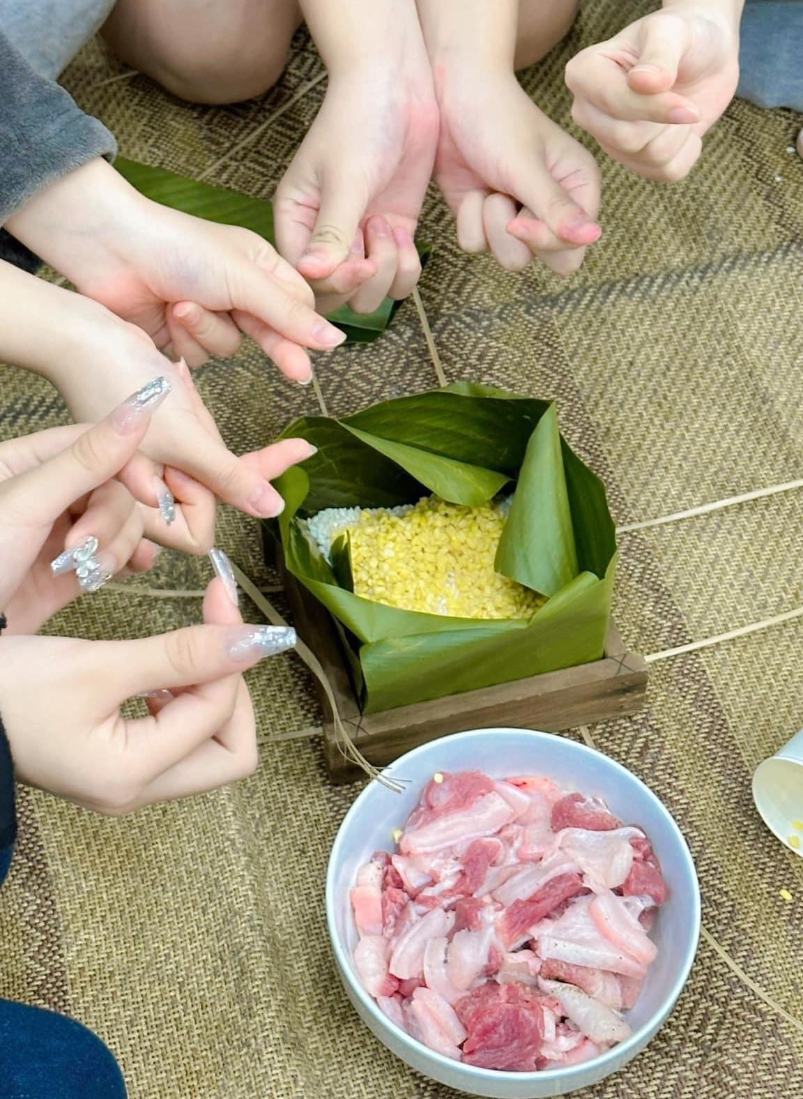 C&aacute;c bạn học vi&ecirc;n tự tay rửa l&aacute;, g&oacute;i b&aacute;nh chưng