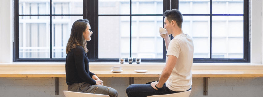 Hai người ngồi uống cà phê nói chuyện về IELTS